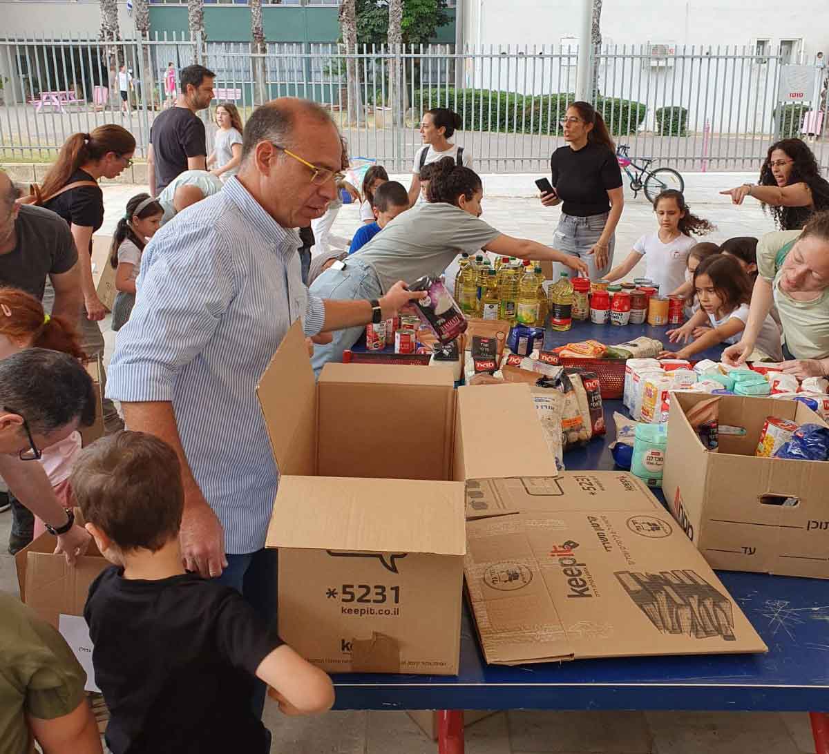 ילדי בבית הספר לפיד מהוד השרון והוריהם אורזים סלי מזון