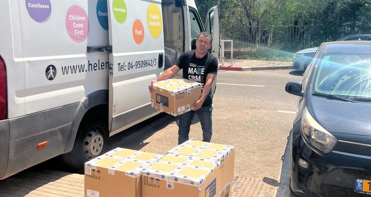 מתנדבים מחלקים ערכות לימוד אנגלית של הלן דורון (צילום: אסף לוי)
