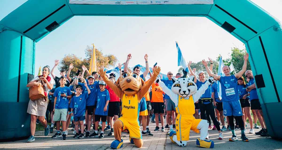 מרוץ איתן RUN. בשער הזינוק עומדים הרצים בחולצות כחולות, ולפניהם כורעים ברך שני רצים בתלבושת צהובה ומסיכות של חיות על ראשם. על החולצה של אחד מהם כיתוב באנגלית: Playtika