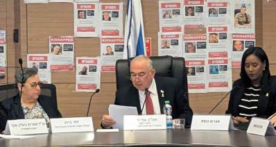 חבר כנסת אלי דלל, הליכוד, יו"ר הוועדה לזכויות הילד. מימינו ומשמאלו יושבות שתי נשים, ומיקרופונים לפניהם. על הקיר מאחוריו תמונות של חטופים וחטופות.