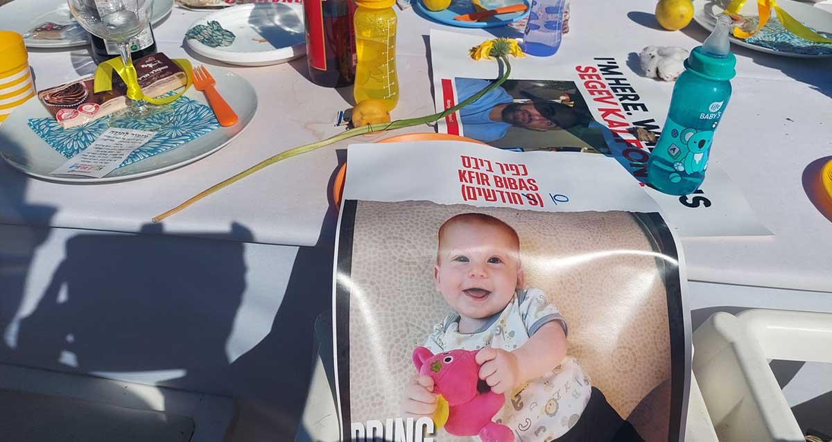 שולחן שבת עבור החטופים, כיכר החטופים, תל אביב. הכיסא של התינוק כפיר ביבס. נחטף בגיל 9 חודשים, היום בן 10 חודשים. Kfir Bibas