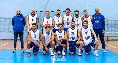 קבוצת הכדורסל של קהילת שבט הנובה. 11 שחקנים ושני מאמנים בצילום קבוצתי, חמישה כורעים ברך ושישה עומדים אחריהם. המאמנים בשני הצדדים. שחקן אחד עם כדורסל ביד. מאחוריהם שער עם רשת.