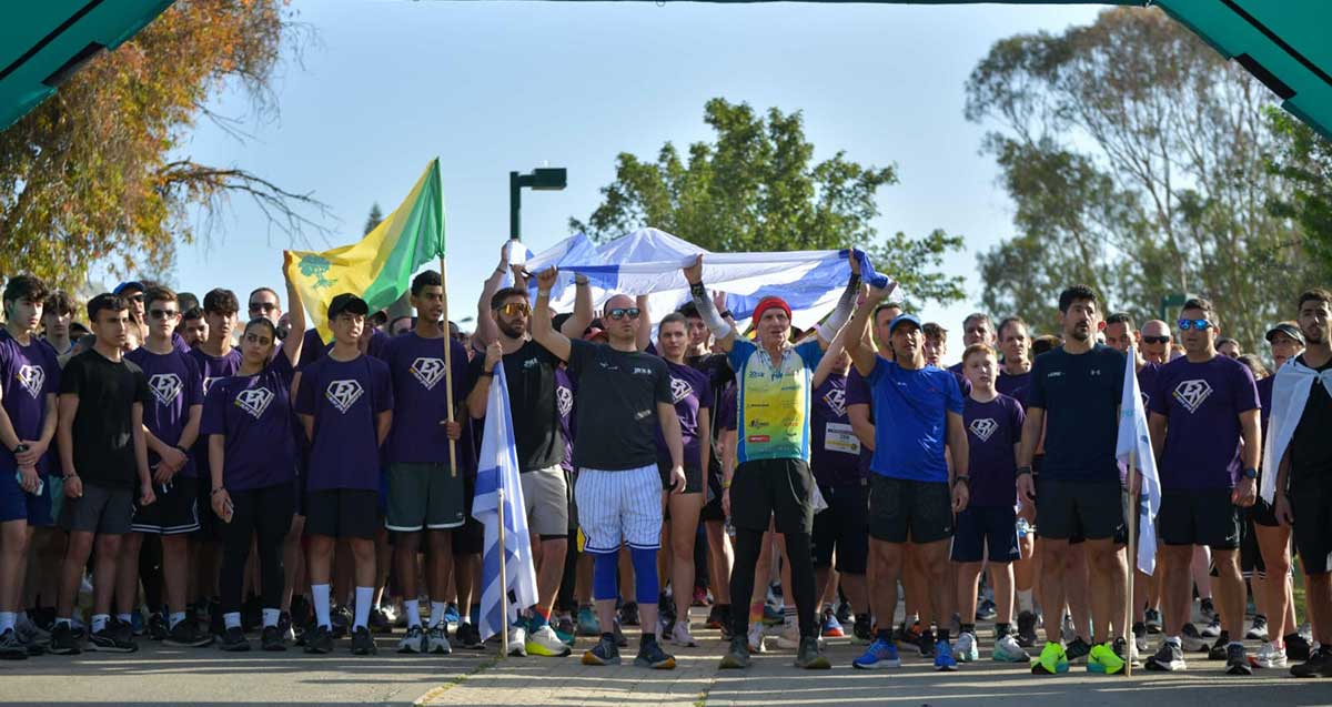 המרוץ השנתי של עמותת "איתן - כל אחד יכול". הרצים בקו הזינוק עם דגלים ובחולצות כחולות.