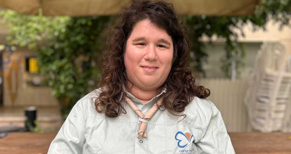 ליאה חיימוב: "במשך שנים לא ראו אותי". תמונה של פלג גוף עליון. חולצה עם הסמל והכיתוב: כנפיים של קרמבו. עניבה סביב הצוואר.