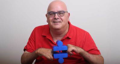 יובל וגנר. איש ממושקף בחולצה אדומה עם מכשיר כחול ביד.