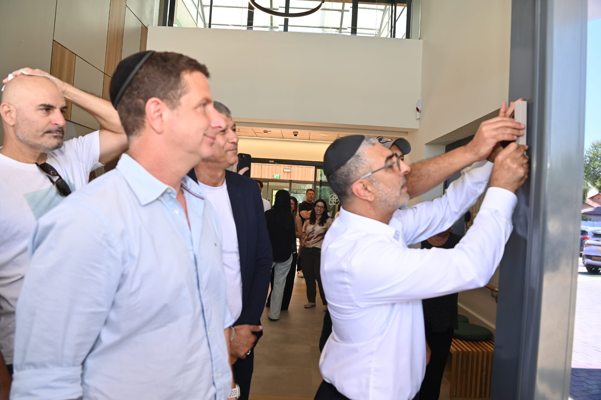 יריב פישר בקביעת מזוזה בבית אילן גילאון. צילום: עיריית הרצליה